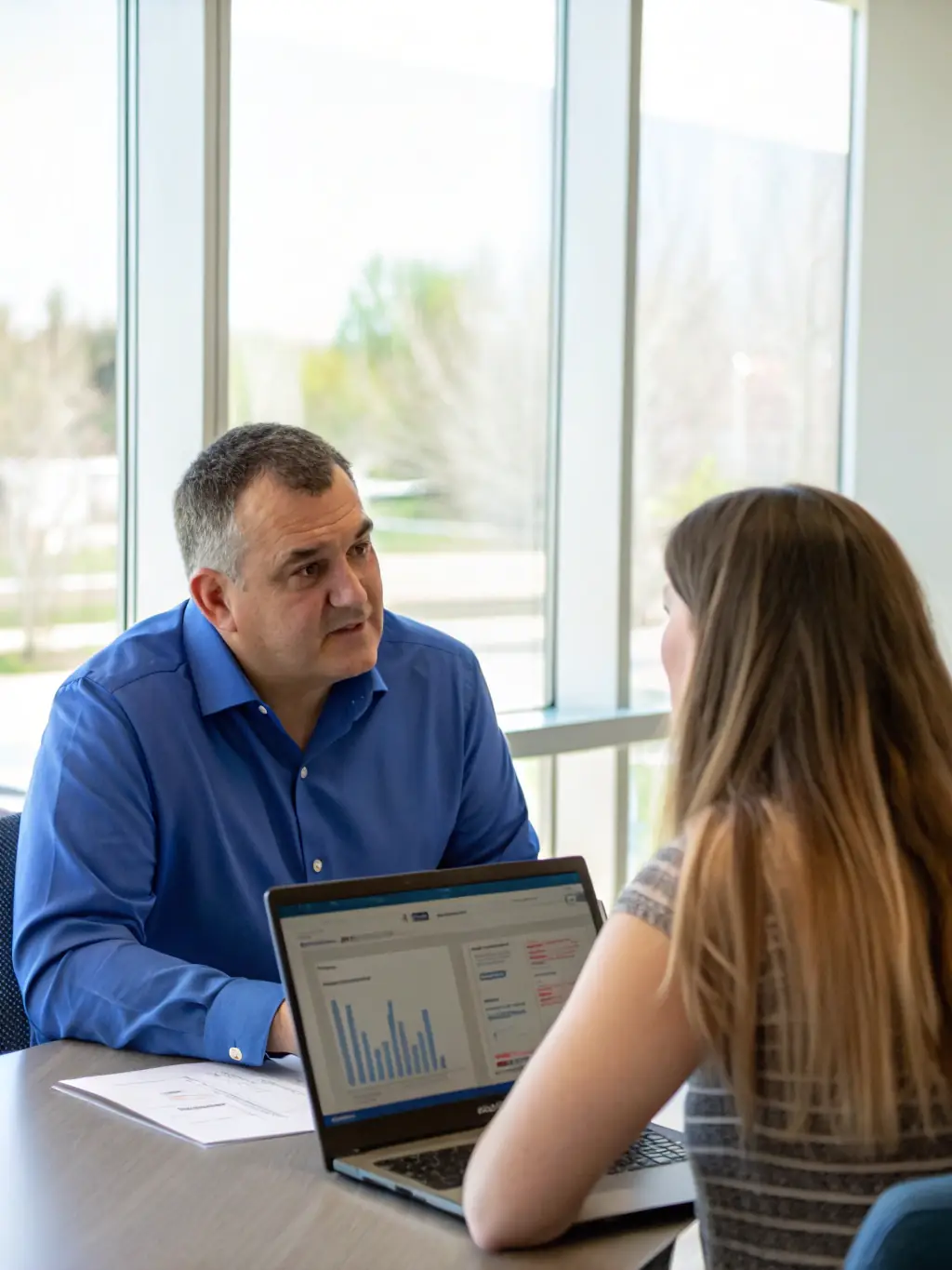 A consultant working with a client, reviewing website accessibility guidelines and discussing strategies for improvement.